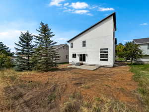 Back of house with a patio area and stucco siding