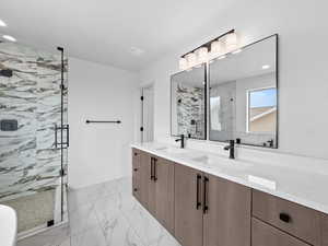 Bathroom with double vanity, a marble finish shower, light marble finish flooring, and recessed lighting