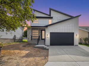 Modern home featuring driveway, an attached garage, and board and batten siding