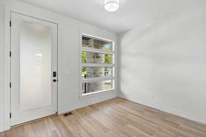 Unfurnished room with light wood-style flooring and baseboards