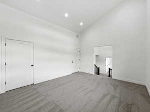 Unfurnished bedroom featuring high vaulted ceiling, carpet floors, and recessed lighting