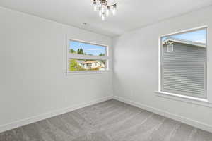 Spare room featuring light carpet and baseboards
