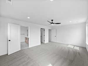 Unfurnished bedroom with light colored carpet, recessed lighting, a ceiling fan, and connected bathroom