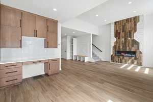 Unfurnished office with a fireplace, light wood-style flooring, recessed lighting, and built in study area