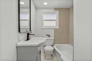 Bathroom with vanity, light tile patterned flooring, shower / bath combination, and recessed lighting