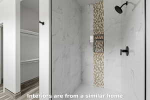 Bathroom featuring a marble finish shower