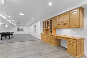 Unfurnished office featuring built in study area, recessed lighting, and light wood finished floors