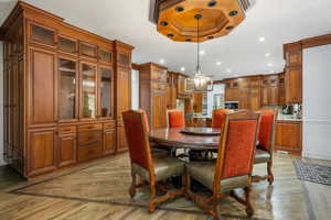 Dining space with light wood-style floors, recessed lighting, ornamental molding, and a chandelier
