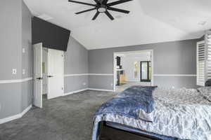 Carpeted bedroom featuring vaulted ceiling and ceiling fan