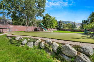 View of community featuring a mountain view and an area to practice putting
