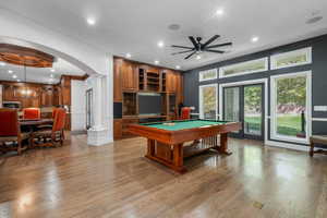 Playroom featuring arched walkways, billiards, recessed lighting, light wood-style flooring, and decorative columns