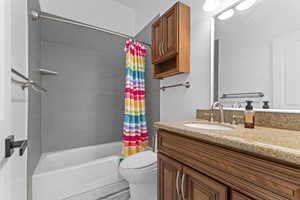 Full bathroom featuring shower / bathtub combination with curtain and vanity