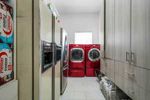 Laundry room featuring light tile patterned floors and washing machine and dryer