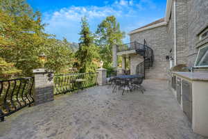 Patio / terrace with outdoor dining space, an outdoor kitchen, and stairway