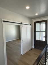 Foyer featuring recessed lighting, wood finished floors, and a barn door
