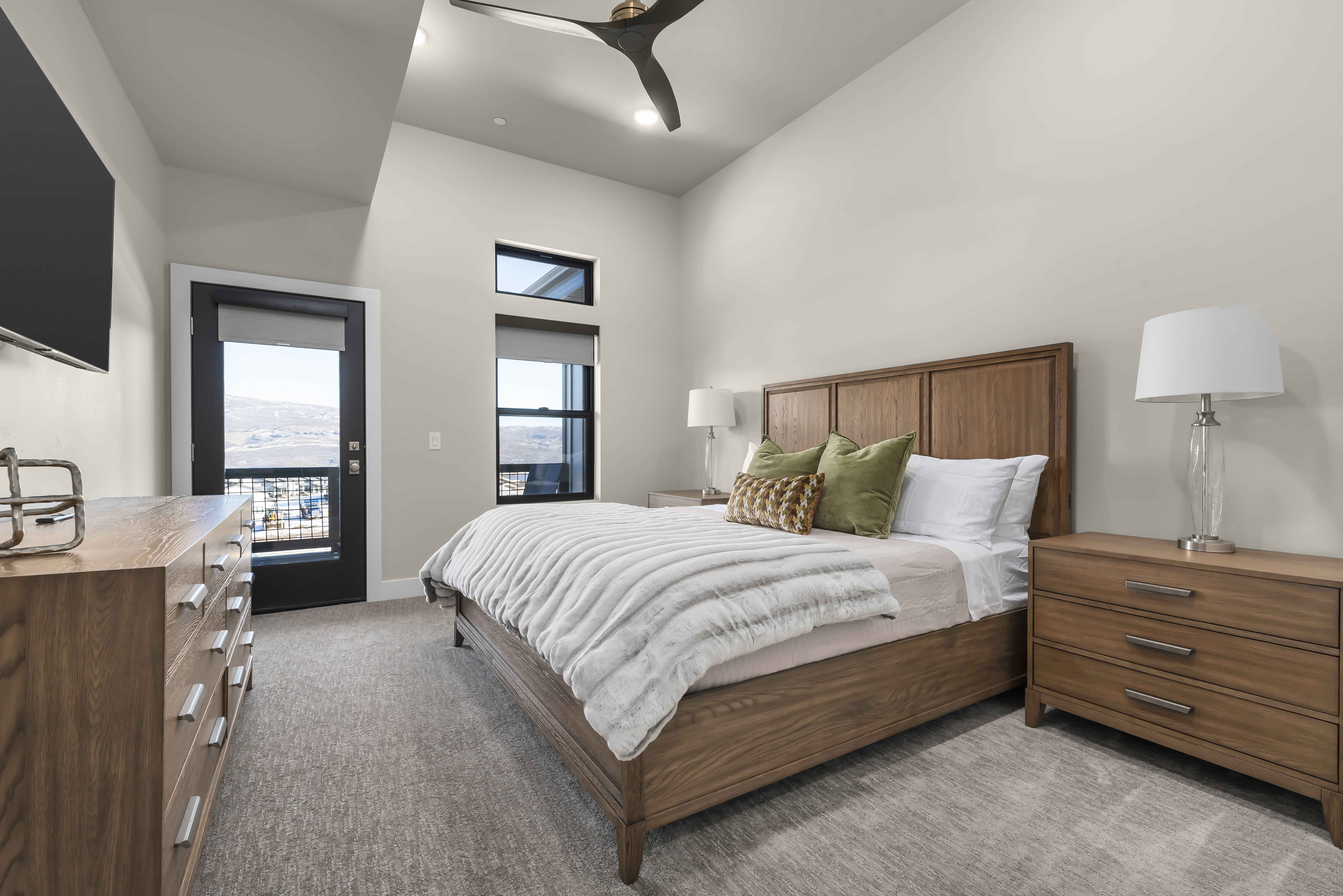 Bedroom with access to exterior, light colored carpet, a high ceiling, and a ceiling fan