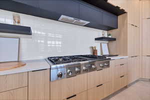 Kitchen featuring stainless steel gas cooktop, open shelves, light tile patterned flooring, and light brown cabinetry
