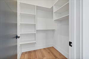 Walk in closet with light wood-style flooring