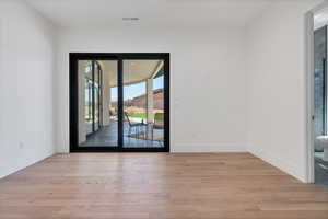 Doorway to outside with hardwood / wood-style flooring and baseboards