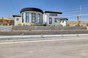 Contemporary home with a standing seam roof, a metal roof, stone siding, and stucco siding