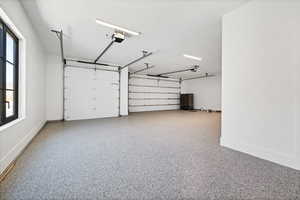 Garage with baseboards and a garage door opener