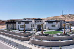 Prairie-style home featuring a metal roof, stucco siding, and a standing seam roof