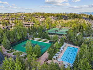 View of swimming pool with a tennis court and a residential view