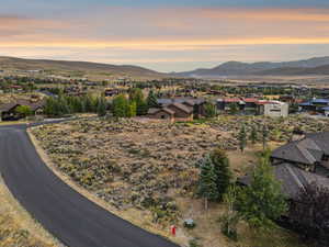 Bird’s-eye view of Lot 36 with the Promontory Club and mountain silhouettes illuminated by dusk.