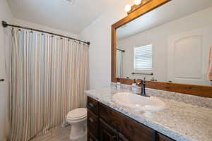 Bathroom featuring vanity, curtained shower, and a textured ceiling