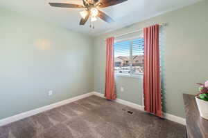 Carpeted empty room featuring a textured ceiling and a ceiling fan