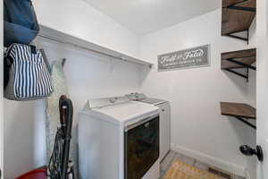 Laundry room featuring washing machine and clothes dryer and a textured ceiling
