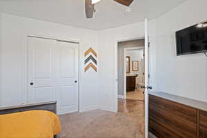 Bedroom featuring light colored carpet, a closet, and ceiling fan