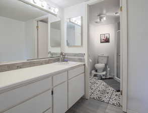 Full bathroom with vanity, a stall shower, and dark tile patterned floors