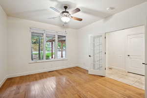 Office with wood flooring, french glass doors and large closet.