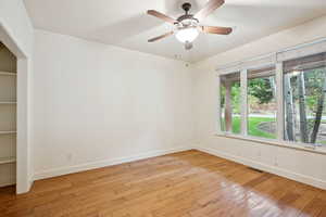 Office with wood flooring, french glass doors and large closet.