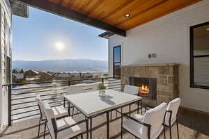 Balcony with outdoor dining space, a mountain view, and an outdoor stone fireplace