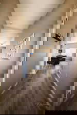 Corridor with dark wood-style floors and vaulted ceiling