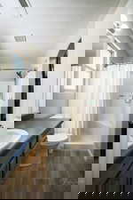 Bathroom with vanity, wood finish floors, a stall shower, and a textured ceiling