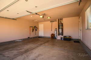 Garage featuring water heater and a garage door opener