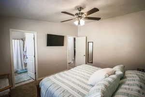 Bedroom featuring a ceiling fan and a textured ceiling