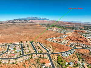 Aerial view of property's location with a mountain backdrop and nearby suburban area