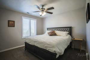 Bedroom featuring dark colored carpet and a ceiling fan
