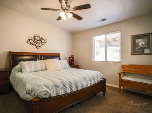 Bedroom with dark colored carpet and a ceiling fan
