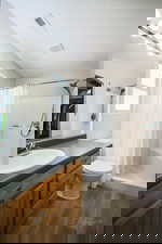 Bathroom featuring vanity, a stall shower, and dark wood-style flooring