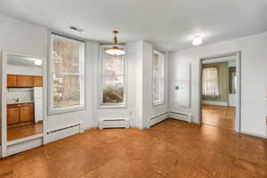 Unfurnished dining area with a baseboard heating unit and plenty of natural light