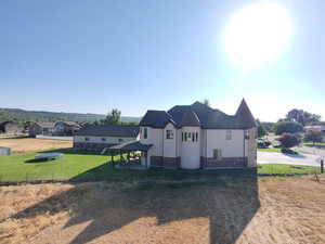 View of side of home with a patio, stucco siding, stone siding, and a residential view