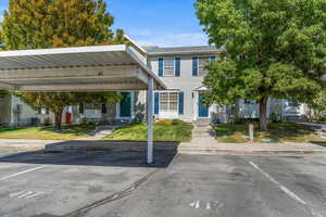View of front facade featuring covered parking and a front lawn