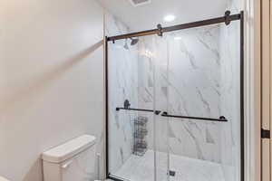 Bathroom with a marble finish shower