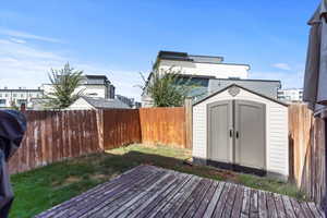 Wooden deck with a fenced backyard and a shed