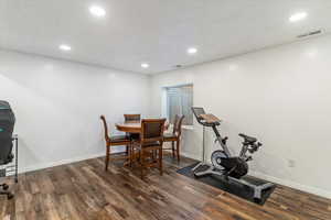 Workout room with recessed lighting, dark wood-style flooring, and a textured ceiling